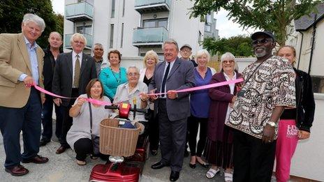 Bill Randall, chairman of the Housing Committee cutting the ribbon with other councillors, residents and tenant representatives