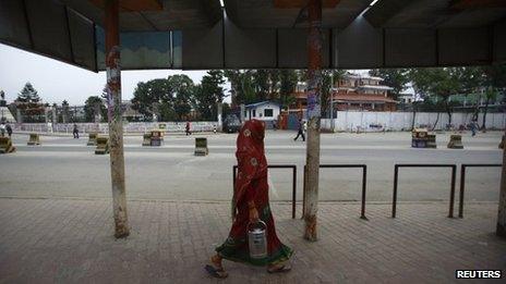 A woman walks past an empty bus stand during a general strike in Kathmandu September 12, 2013