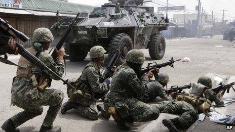 Government troopers aboard an Armoured Personnel Carrier fire at Muslim rebels in an operation to rescue scores of hostages being used as human shields by the rebels on the fourth straight day Thursday, 12 September 2013 at Zamboanga city in southern Philippines