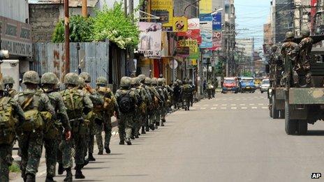 Government soldiers patrol a street as during heavy fighting between rebels and government forces as the stand-off enter its fourth day in Zamboanga city, in southern island of Mindanao, on 12 September 2013