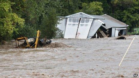 The overflowing St. Vrain River swamps a structure and a piece of heavy machinery following overnight flash flooding, one mile east of Lyons, Colorado 12 September 2013