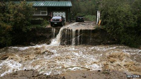 A home and car are stranded after a flash flood in Coal Creek destroyed the bridge near Golden, Colorado 12 September 2013