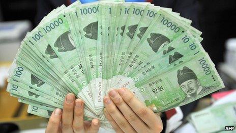 This photo taken on 1 February 2013 shows a bank employee holding South Korean won banknotes at the Korea Exchange Bank in Seoul