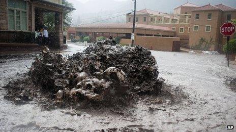 Floodwaters erupt out of a sewer on Canon Avenue in Manitou Springs, Colorado, on Thursday