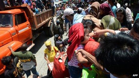 Residents board a truck as they are transported to a safer place after the government enforced a forced evacuation of villagers near the stand-off between government forces and Muslim rebels in Zamboanga City in southern island of Mindanao on 13 September 2013