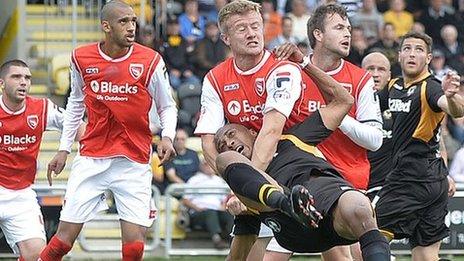 Chris Zebroski of Newport County tangles with the Morecambe defence
