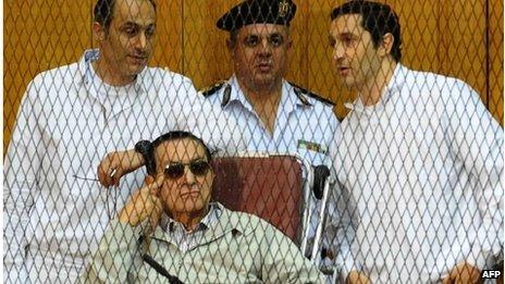 Hosni Mubarak and his two sons Alaa (R) and Gamal stand behind bars during their trial at the Police Academy on 14 September