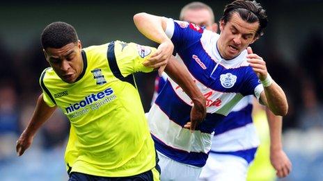 Tom Adeyemi and Joey Barton battle for the ball