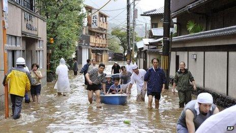 Hotel guests get a boat ride through a flooded street after the Katsura river was overflooded by torrential rains caused by a powerful typhoon in the country's popular tourist destination of Kyoto, western Japan, Monday, 16 September 2013