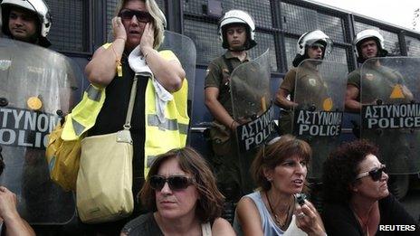 School guards sit in front of police outside government ministry (16 Sept 2013)