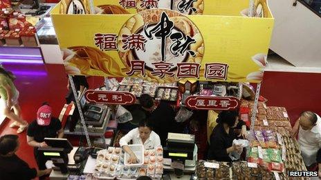 Consumers look at mooncakes in a shopping mall in Shanghai 11 September 2013