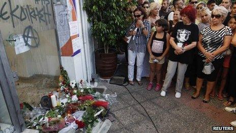 Flowers and mourners at the spot where Pavlos Fyssas was fatally stabbed in Athens