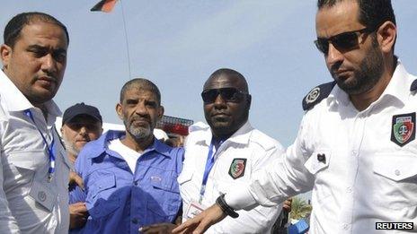 Abdullah al-Senussi arrives for a hearing at a courtroom in Tripoli September 19, 2013