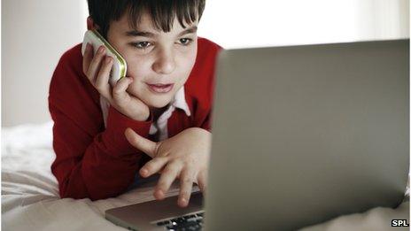 A boy with a laptop and a smartphone