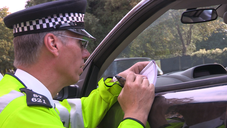A police officer questions a driving instructor