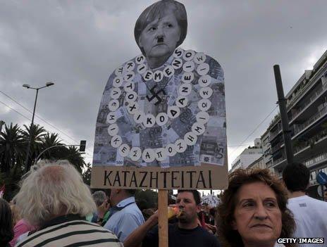 A Greek protestor holds a placard criticising Angela Merkel