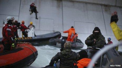 Greenpeace image it says shows a Russian coastguard pointing a gun at activist