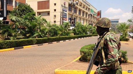 A soldier moves to take up a position outside an upscale shopping mall, seen background, in Nairobi, Kenya Saturday 21 September 2013.