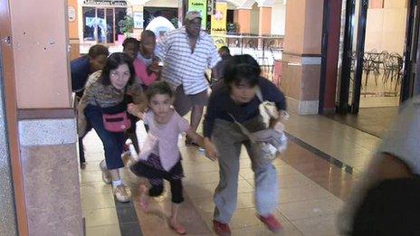 An image grab taken from AFP TV shows civilians taking cover following an attack by masked gunmen in a shopping mall in Nairobi on September 21, 2013