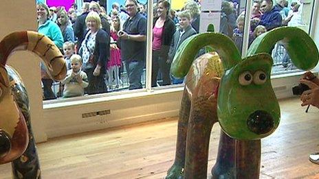 Gromit statues, with queues of people in window behind