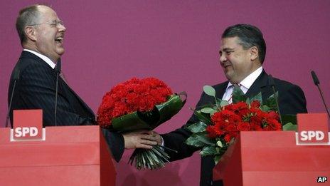 SPD candidate Peer Steinbrueck is given a bunch of flowers by the party's chairman, Sigmar Gabriel