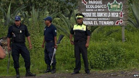 Security forces guard the entrance to a ranch where 13 bodies were found in August 2013