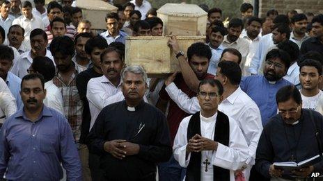 Pakistanis carry coffins during the funeral of victims of a suicide attack on a church in Peshawar, Pakistan, Tuesday, Sept. 24, 2013.