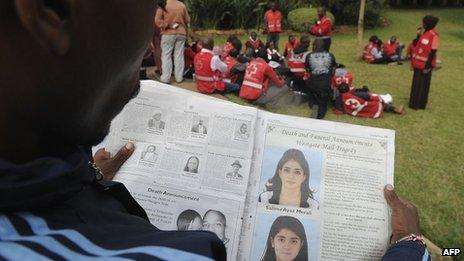 A man looks at a newspaper bearing funeral arrangements of victims of the Westgate mall terrorist attack in Nairobi, on 24 September 2013