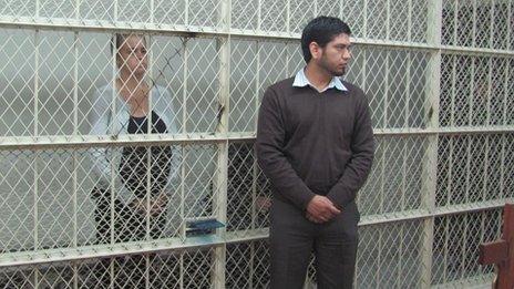 Melissa Reid stands in a holding cell during a court hearing on 24 September 2013, while Michaella McCollum sits on a bench