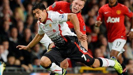 Luis Suarez is tackled by Phil Jones