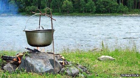 A pan hanging over a wood fire