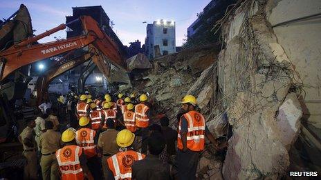 Rescue crew members search for survivors at the site of a collapsed residential building in Mumbai