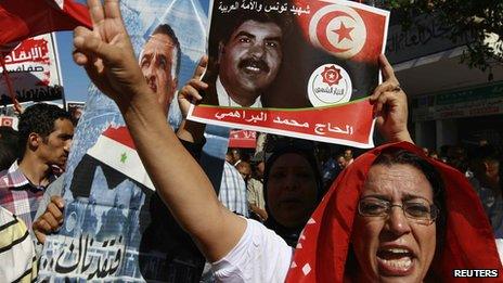 Protesters hold up a picture of murdered opposition leader Mohammed Brahmi during an anti-government demonstration in Tunisia.