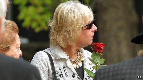 Carol Thatcher holds a red rose before placing it with the ashes of her mother, former Prime Minister Baroness Margaret Thatcher