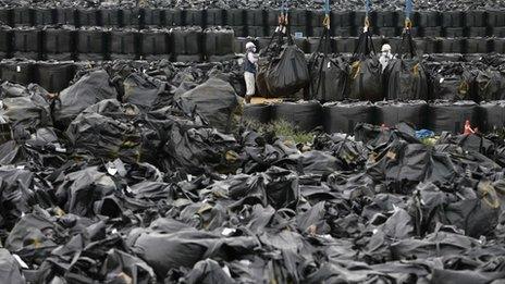 Workers move waste containing radiated soil from storage site in Naraha town