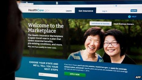 A woman looks at the HealthCare.gov website on 1 October 2013