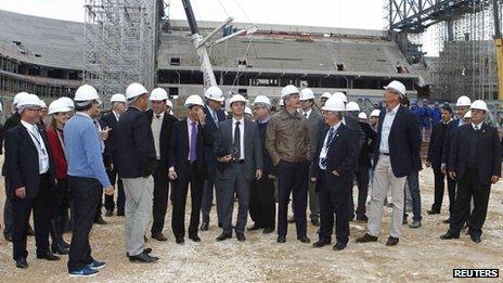 Jerome Valcke (5th from right) and Brazil's Sports Minister Aldo Rebelo (centre in brown jacket) tour the construction site of the Arena da Baixada stadium