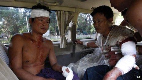 In this Tuesday, Oct. 1, 2013 photo, two injured Rakhine men sit in a car as they prepare to go to hospital in Thandwe, Rakhine State, western Myanmar.