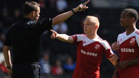 Swindon's Alex Pritchard and Nathan Byrne discuss an incident with the referee