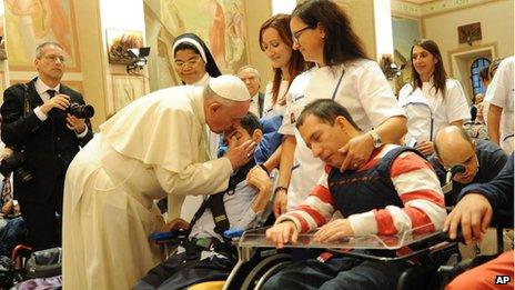 Pope Francis caresses a person during his visit at the Serafico Insitiute for disabled children, in Assisi, Italy, on 4 October 2013