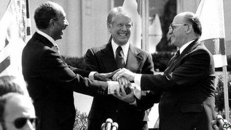 Egyptian President Anwar Sadat, left, US President Jimmy Carter, centre, and Israeli Prime Minister Menachem Begin clasp hands on the north lawn of the White House after signing the peace treaty between Egypt and Israel on 26 March, 1979.