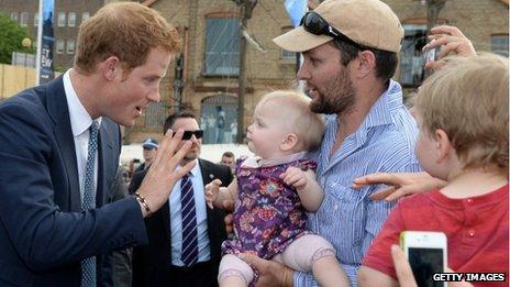 Price Harry greets a baby