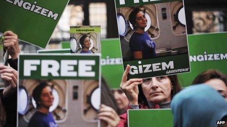 Greenpeace activists hold pictures of their detained colleague Gizem Akhan during a protest in front of the Russian consulate in Istanbul