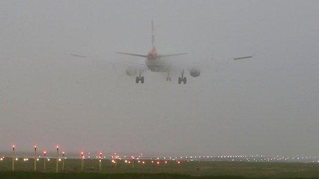 A flight lands at Heathrow Airport in the fog in September