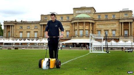 Kevin Standley, groundsman at Wembley Stadium, marks out the the lines of a football pitch in the gardens of Buckingham Palace