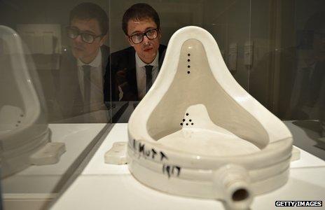 A gallery assistant views Fountain by Marcel Duchamp at The Scottish National Gallery of Modern Art