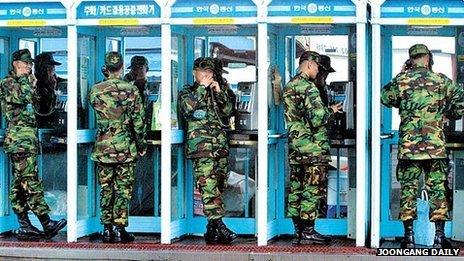 Soldiers using phone boxes in Seoul