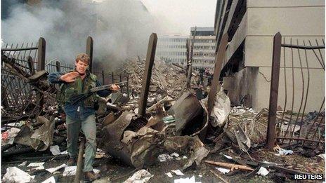A U.S. embassy official secures the area around the embassy building after a powerful bomb blast in Nairobi (7 August 1998)