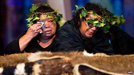 Two members of the Tainui Waka Alliance tribe weep beside the 20 Maori mummified tattooed heads (Toi Moko) returned to New Zealand during a ceremony at Te Papa Museum in Wellington