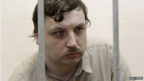 Mikhail Kosenko sits inside a defendants" cage during a court hearing in Moscow (May 2013)